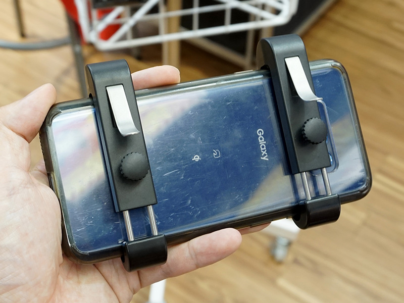 スマートフォンへの取り付け例(中央部にある黒い突起物は固定用ネジ)