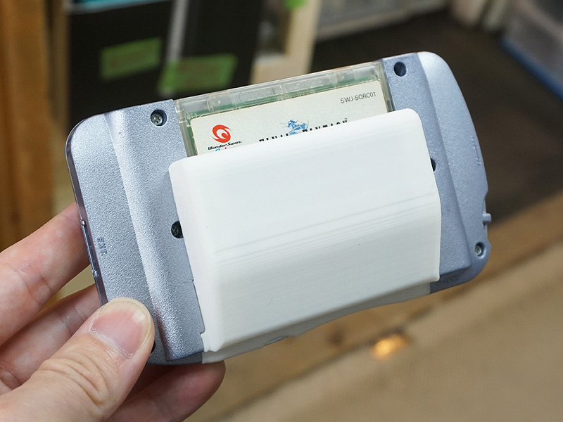 WSColor大容量電池ケース(キット)を組み立て、ワンダースワンカラーに装着した様子。写真は「店頭用サンプル」(非売品)というホワイトカラーモデル