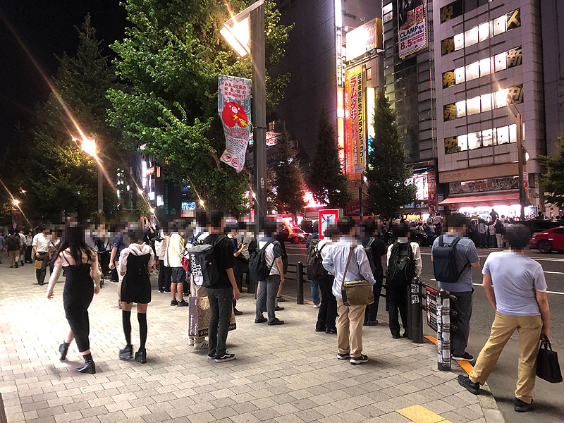 道路の反対側から見物する人も