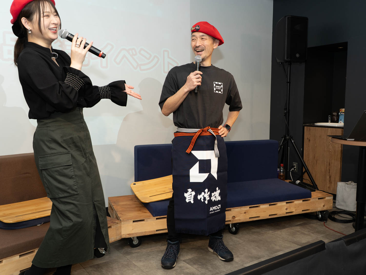 AMD 佐藤美明氏(右)は当日配られたノベルティの「自作魂」前掛けを装着して登場、イベントのMCは鈴木咲さん(左)がつとめた