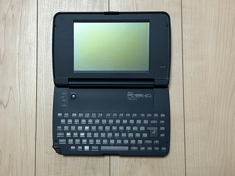 本体の大きさが分かるよう、比較対象として3.5インチFDと一緒に撮影してみました。非常に小さく、また単体であれば画面がほぼ180度近くまで開くようになっています。手前右下にはリセットスイッチがあり、爪楊枝など先が細いもので押すとリセットできました。画面の右側には、コントラスト調節つまみがあります。