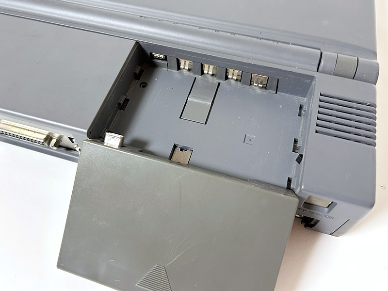 背面は左からテンキーパッド接続コネクタ、マウスコネクタ、RS-232Cコネクタ、プリンタポート、バックアップスイッチ、拡張バスとなっています。バッテリーパックの部分を見ると左端に小さな端子がありますが、ここに接続する形でCRTパックを装着することで外部ディスプレイへ映像を出力できました。