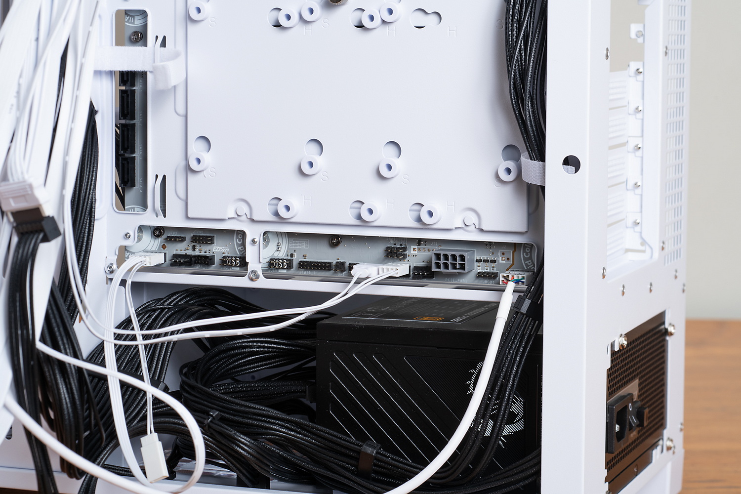 各種ケーブルは、マザーボードベースの穴を通してマザーボードに挿す