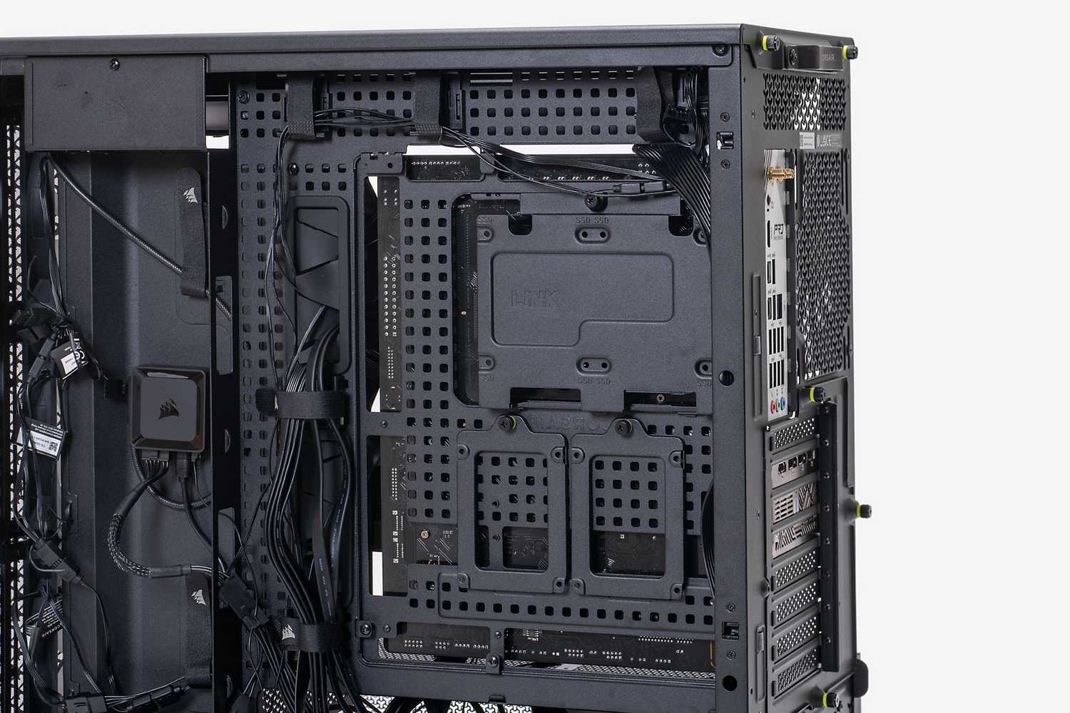 マザーボードベースを裏側から見たところ(写真左)。多数の穴が開けられており、面ファスナーやケーブルタイでケーブルをまとめるのにも使える。iCUE LINKシステムハブにはマグネットが仕込まれており、裏面側の配線しやすく目立ちにくい場所に貼り付けておける(写真右)