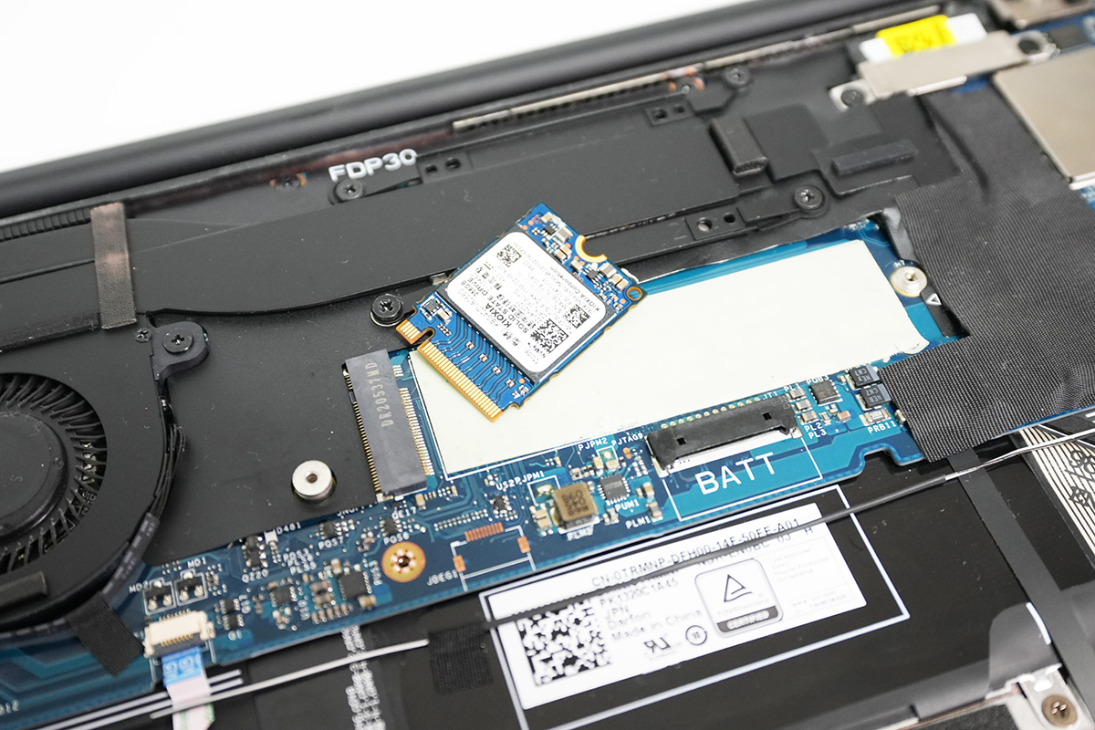 【10】SSDは底面のシートにしっかりくっついているので、少し持ち上げてシートから外し、スライドして抜き取る