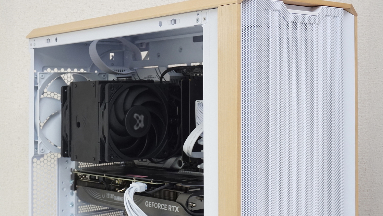 マザーボード下部にピンヘッダーケーブルやファンケーブルを挿す場合は、このようにファンを一時的に外すとよい