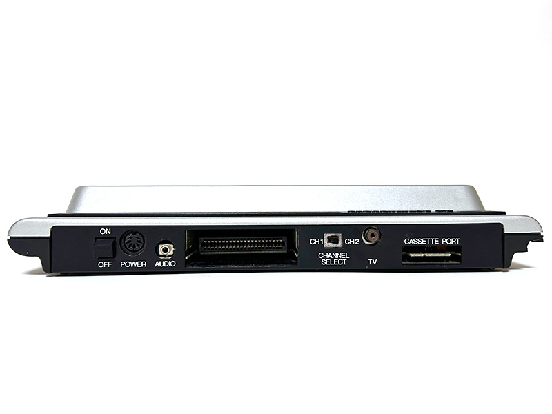 本体背面は左から電源スイッチ、電源コネクタ、オーディオ出力、44ピン拡張バス／カートリッジ・スロット、チャンネルセレクトスイッチ、RF出力端子、コモドールカセットインタフェースと並んでいます。