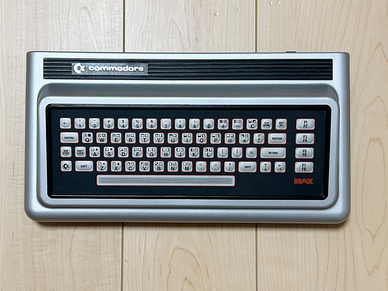 キーボードを、真上から撮影しました。このアングルでは少々のっぺりした感じに見えるかもしれませんが、スペースを除くキーは中央部分が少しだけふっくらと盛り上がっていて、押すと“ヘコッ”という感じで凹みます。スペースキーは反応がありませんが、軽く叩けばスペースが入力されました。電源は真上と真横から撮影しましたが、比較対象として3.5インチFDを置いています。これで、どの程度大きいのかが分かると思います。