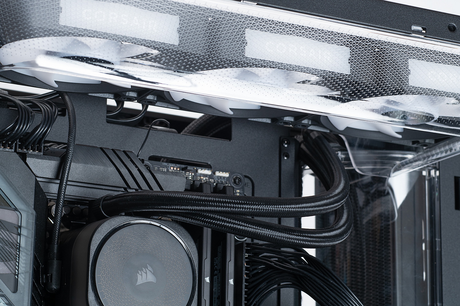 水冷クーラーのチューブはダイバータダクトの上部側を通す。ダクトを一旦取り外して作業するのが吉だ。難しいというほどではないのだが、ナイロン・ブラシが上手いこときれいに揃わないことがあるのが悩ましい。天板に電源スイッチとUSBポート、オーディオ端子がある関係で、ケーブルとチューブがチャンバー上部に集中しがちだ(手で押さえているケーブルの束が前面インターフェース類の接続ケーブル)