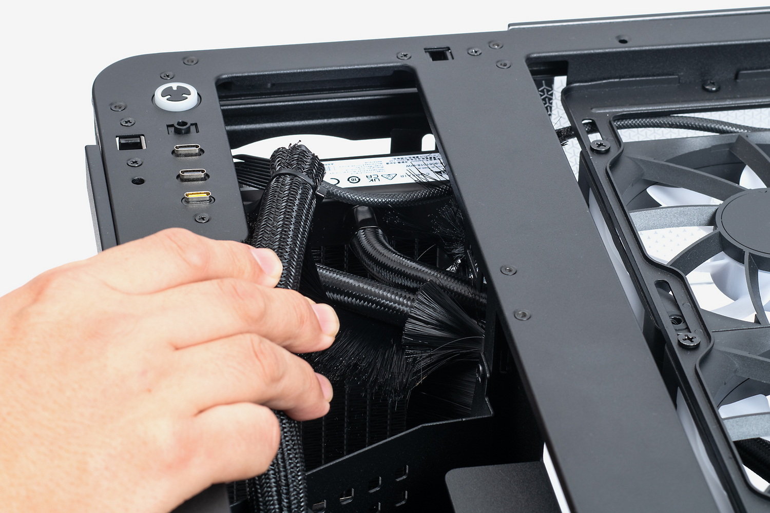 水冷クーラーのチューブはダイバータダクトの上部側を通す。ダクトを一旦取り外して作業するのが吉だ。難しいというほどではないのだが、ナイロン・ブラシが上手いこときれいに揃わないことがあるのが悩ましい。天板に電源スイッチとUSBポート、オーディオ端子がある関係で、ケーブルとチューブがチャンバー上部に集中しがちだ(手で押さえているケーブルの束が前面インターフェース類の接続ケーブル)