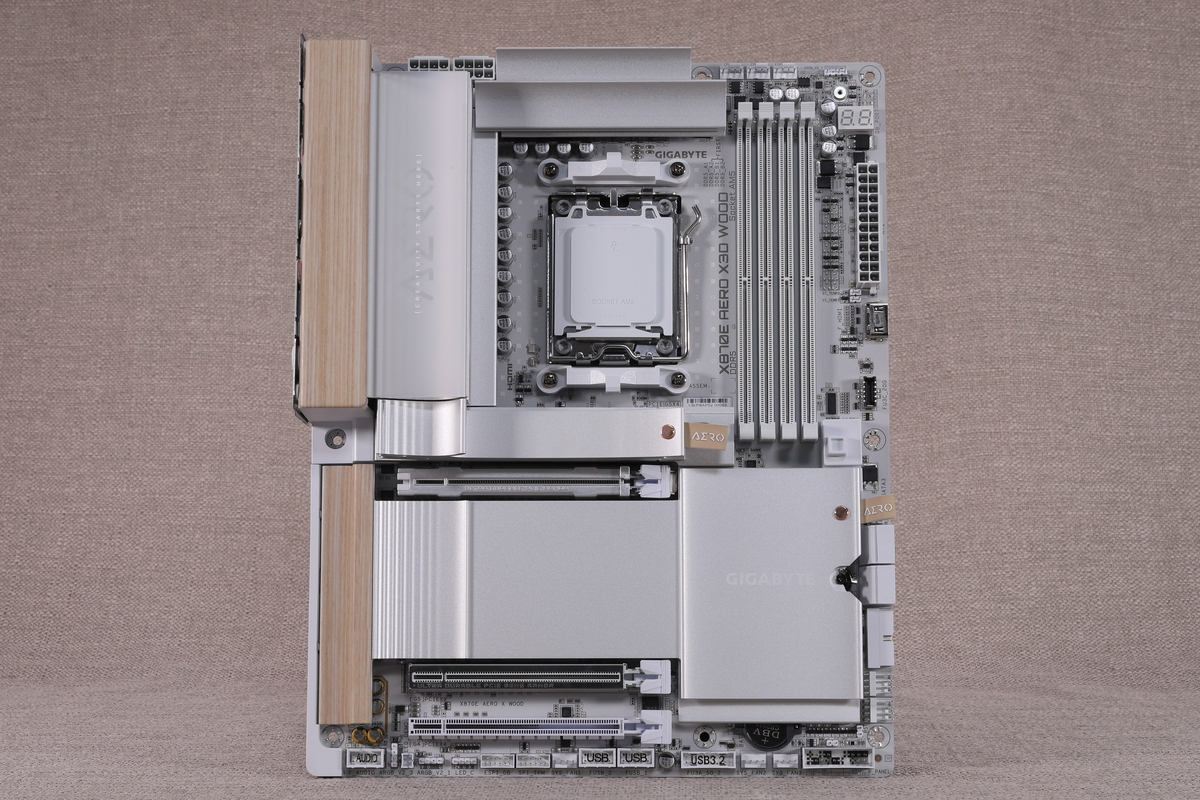 X870E AERO X3D WOOD。白を基調としたカラーリングを採用しつつ、ボード左端に木目調パネルを搭載している