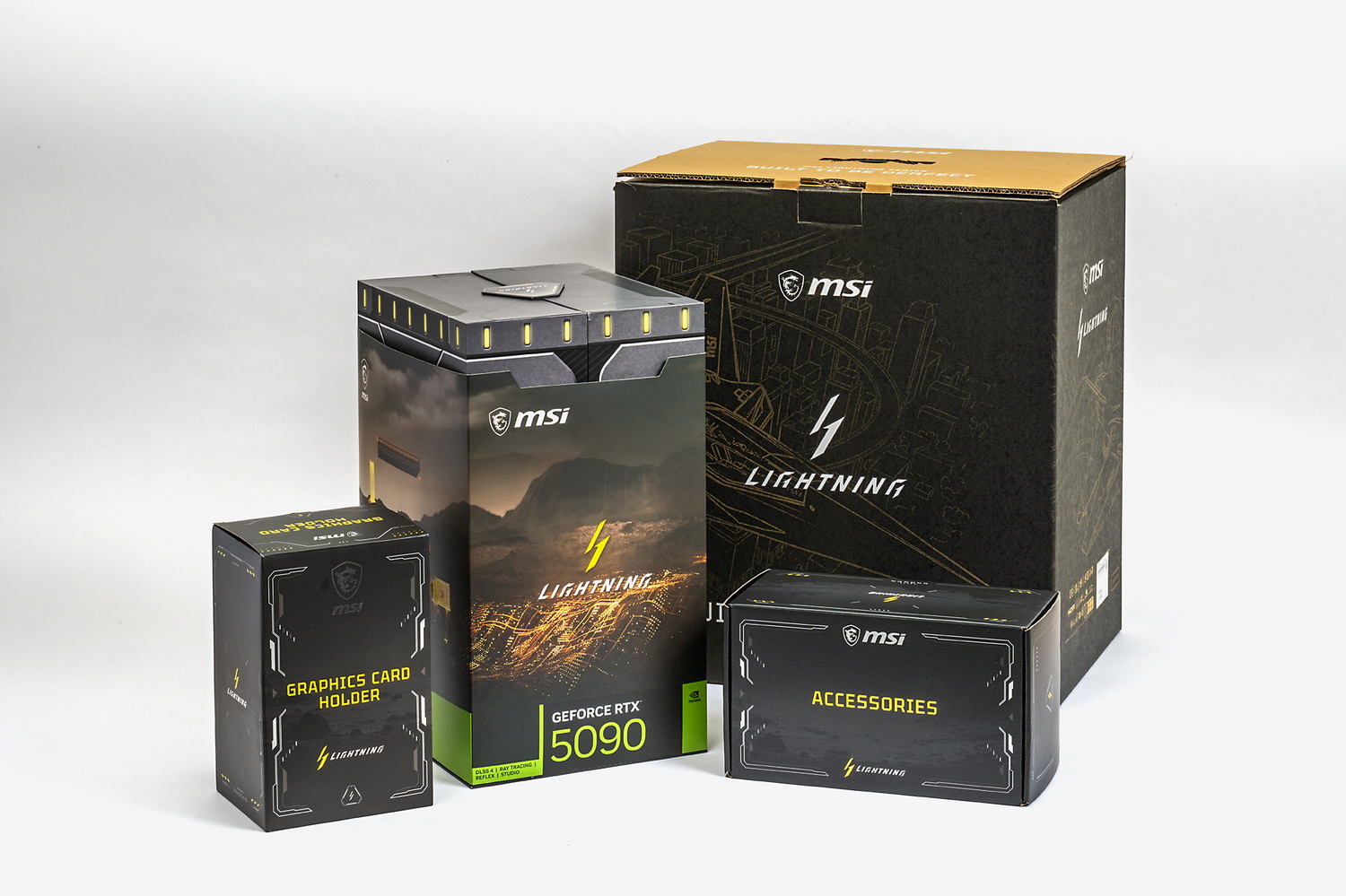 RTX 5090 LIGHTNING Zは外箱（右奥）からして巨大。写真では実感しにくいが、外箱はデュアルチャンバー式PCケースと遜色ない、いやそれ以上の大きさである。中央やや左の縦長の箱にLIGHTNING Z本体が縦に収まっている