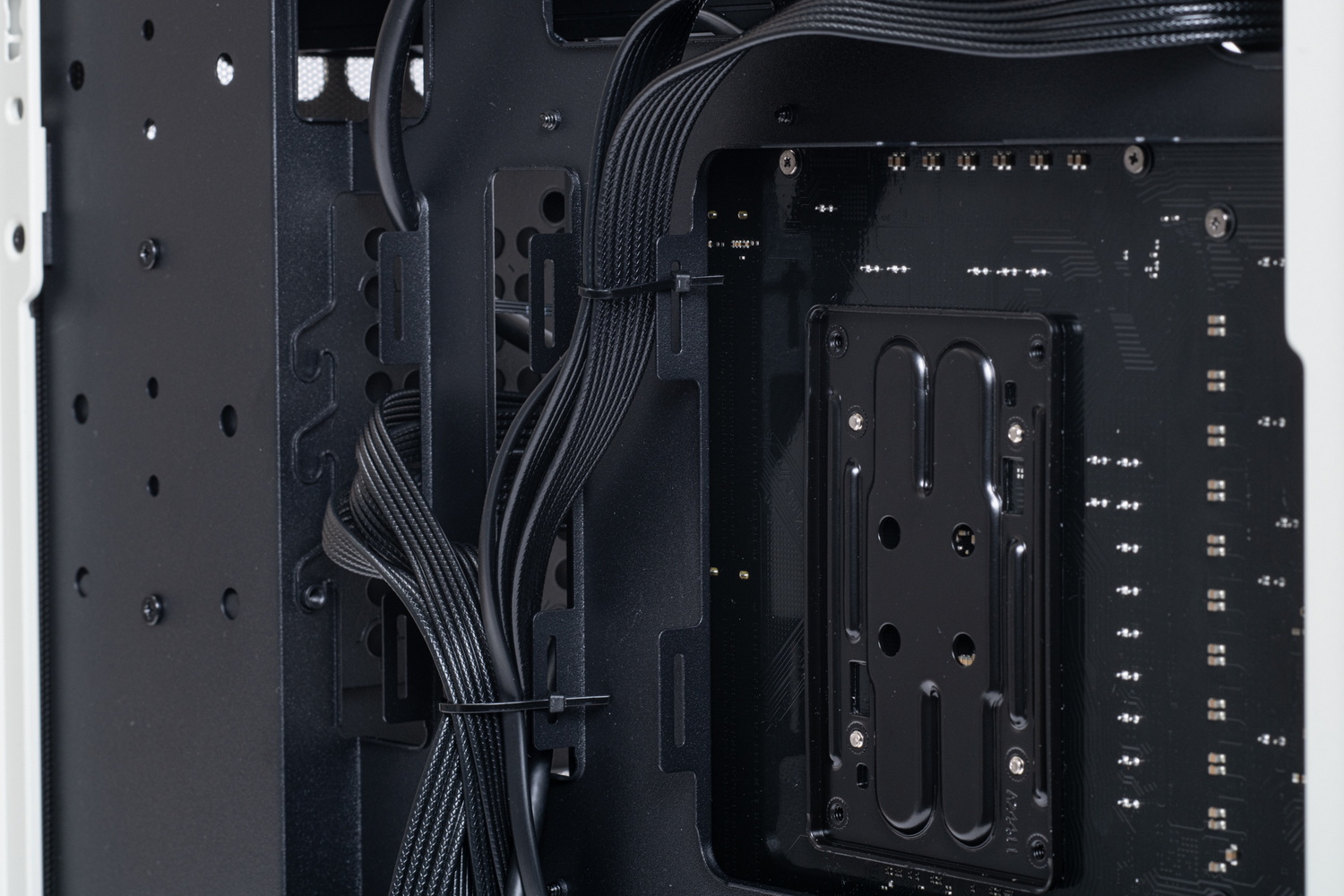 裏面配線は、前面からマザーボード裏面に流す電源ケーブルを中央付近でまとめる感じで整理するとよい。ここにはケーブルタイを固定するためのフックがいくつもあって作業がしやすい