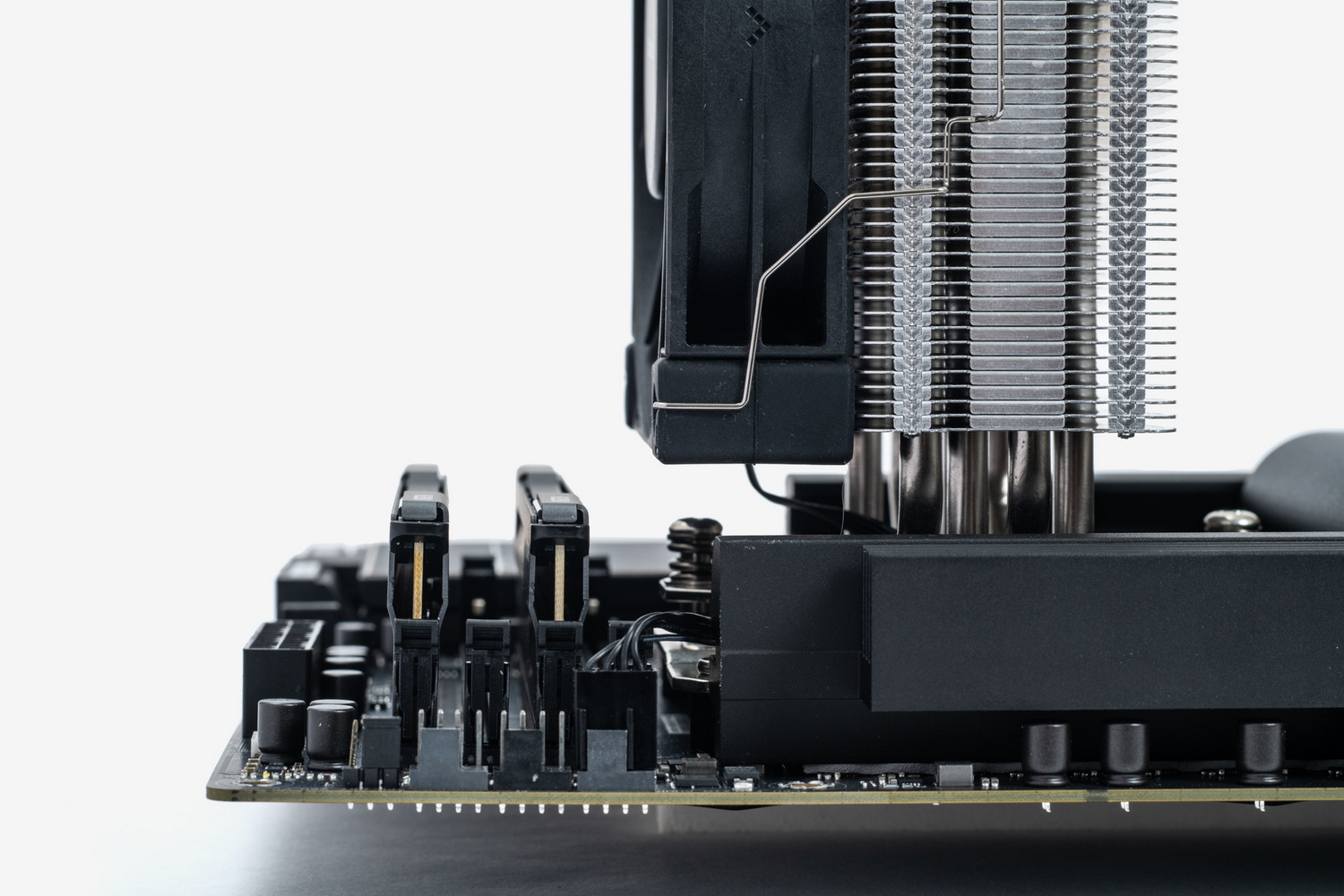 サンプルに使用したクーラーはそもそもメモリスロットにクーラーがかぶらない構造になっているため物理干渉を意識する必要はないが、横から見た写真でクーラーとメモリの高さの位置関係は分かるだろう。普及価格帯のクーラーのサイズ感はこのくらいのものが多いので、仮にスロット上空に重なる場合でも、メモリにファンが接触することはないだろう