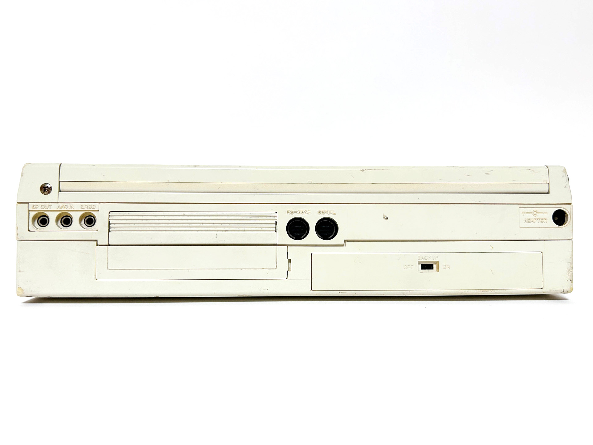 背面は左からスピーカー出力端子、A/D入力端子、バーコードリーダ接続端子、RS-232Cコネクタ、シリアルポート、ACアダプタ接続口、その下にバックアップのオンオフスイッチが設けられていました。底面には、ROMソケットとディップスイッチがありました。