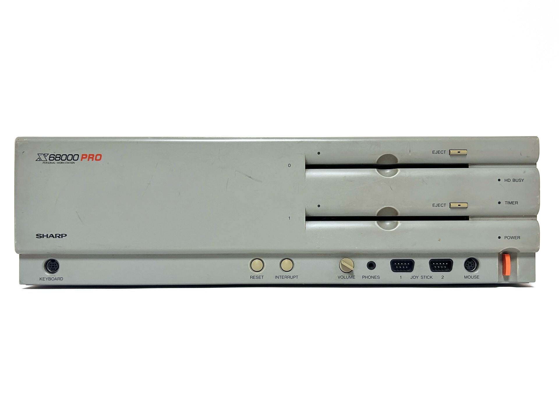 正面は左から、キーボード接続コネクタ、リセットボタン、インタラプトボタン、ボリュームつまみ、ヘッドフォン端子、ジョイスティックポート×2、マウスコネクタ、電源スイッチと並んでいます。電源スイッチの上には、TIMERとHD BUSYのインジケータも見えます。