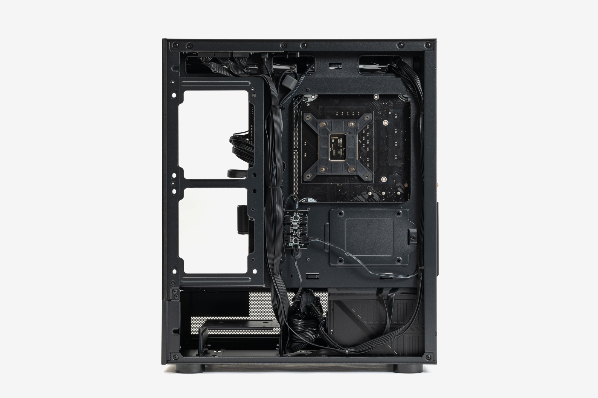 右側面カバーを外したPC裏面。ケーブル類はもちろんきれいに整理されている。3基のファンはファンハブに接続されている。2.5インチおよび3.5インチのSSD/HDDを取り付けるシャドーベイも用意されている