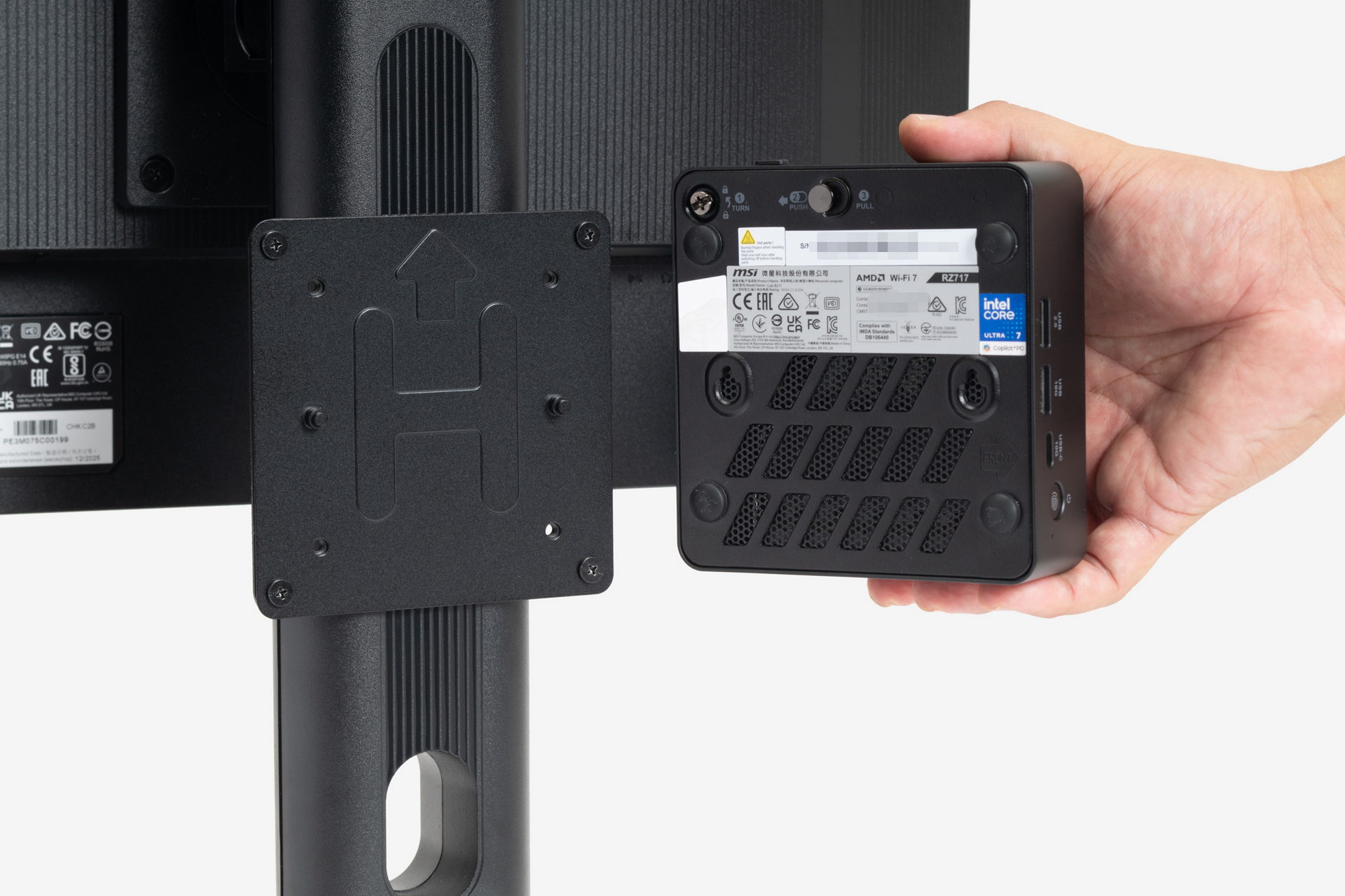 取り付けたプレートの“H”マークの両脇に突起があるので、ここにCubi NUC AI+ Seriesの底面にある穴を合わせて引っかけて固定する。しっかり固定できる取り付け方向が決まっているので、本体の天地の向きに注意