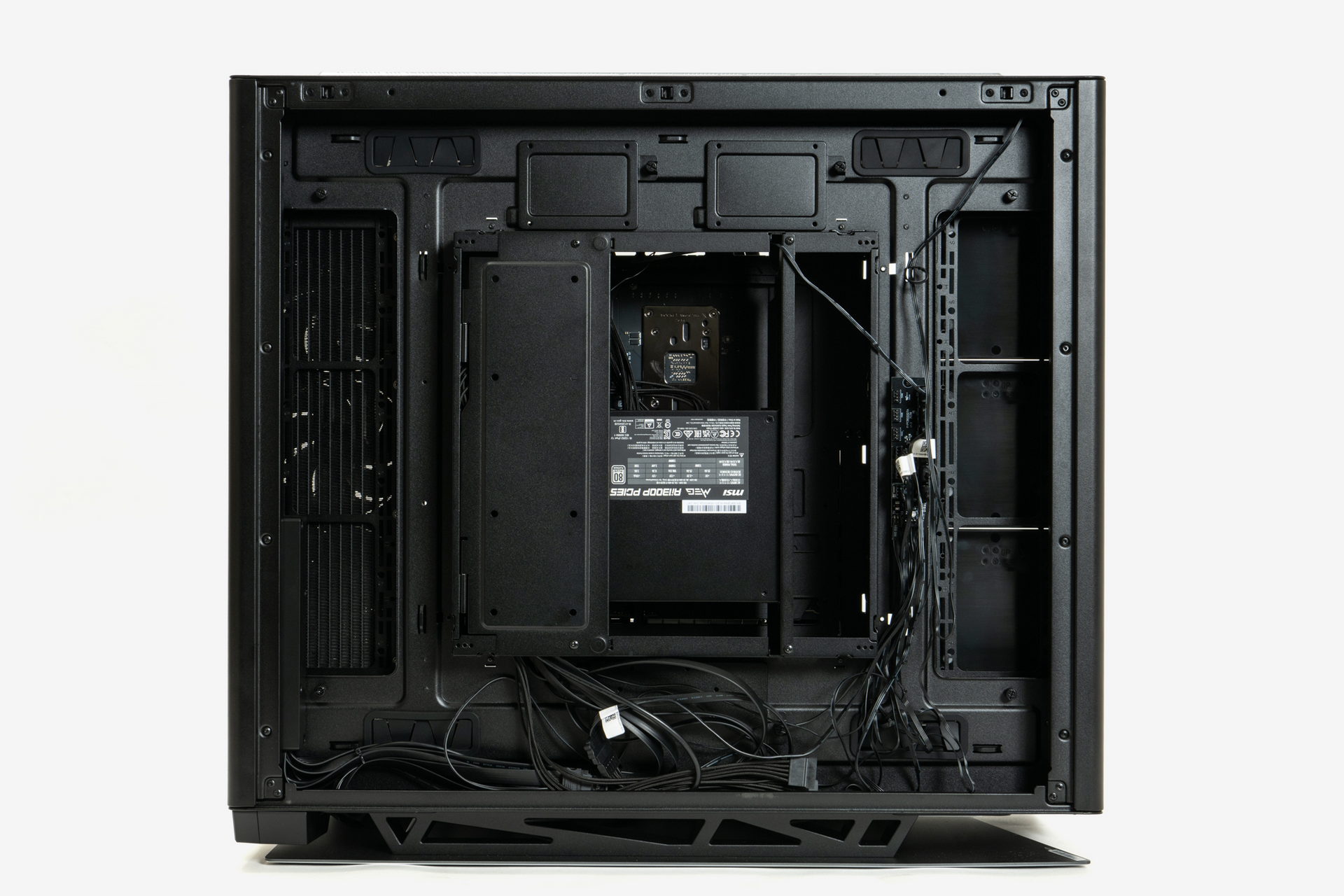 組み込み後の右側面内部(裏面)。電源ユニットからのケーブルは中央のマザーボードベースのユニット内に収まる。そのほかのファン/LED類、フロントパネルのケーブルは下部のスペースで、マザーボードや電源と接続する必要があるストレージ関連は中央のユニットや周辺のスペースを上手く使って引き回そう