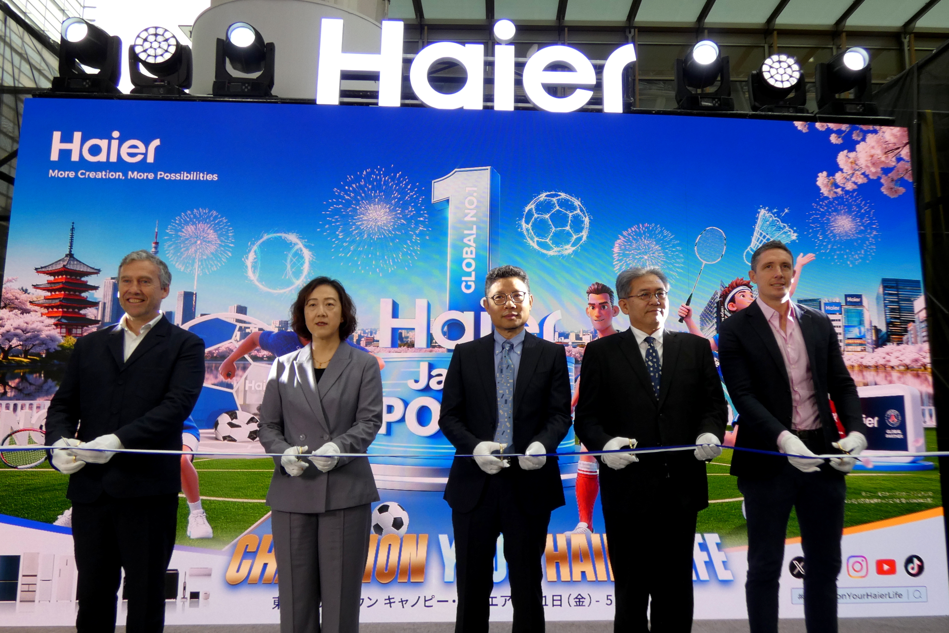 イベント開幕にあわせ関係者が駆けつけテープカット。（左から）パリ・サンジェルマンFC CROのリチャード・ヒューズルグレイブ氏、ハイアールスマートホーム グローバルブランド部 部長の王娜氏、ハイアールグループ副総裁 兼 ハイアールスマートホーム ジャパンリージョン CEOの杜鏡国氏、ハイアールジャパンセールス 執行役員 副社長の乾修明氏、リヴァプールFC ディレクター/パートナーシップセールスのピーター・はロッド氏