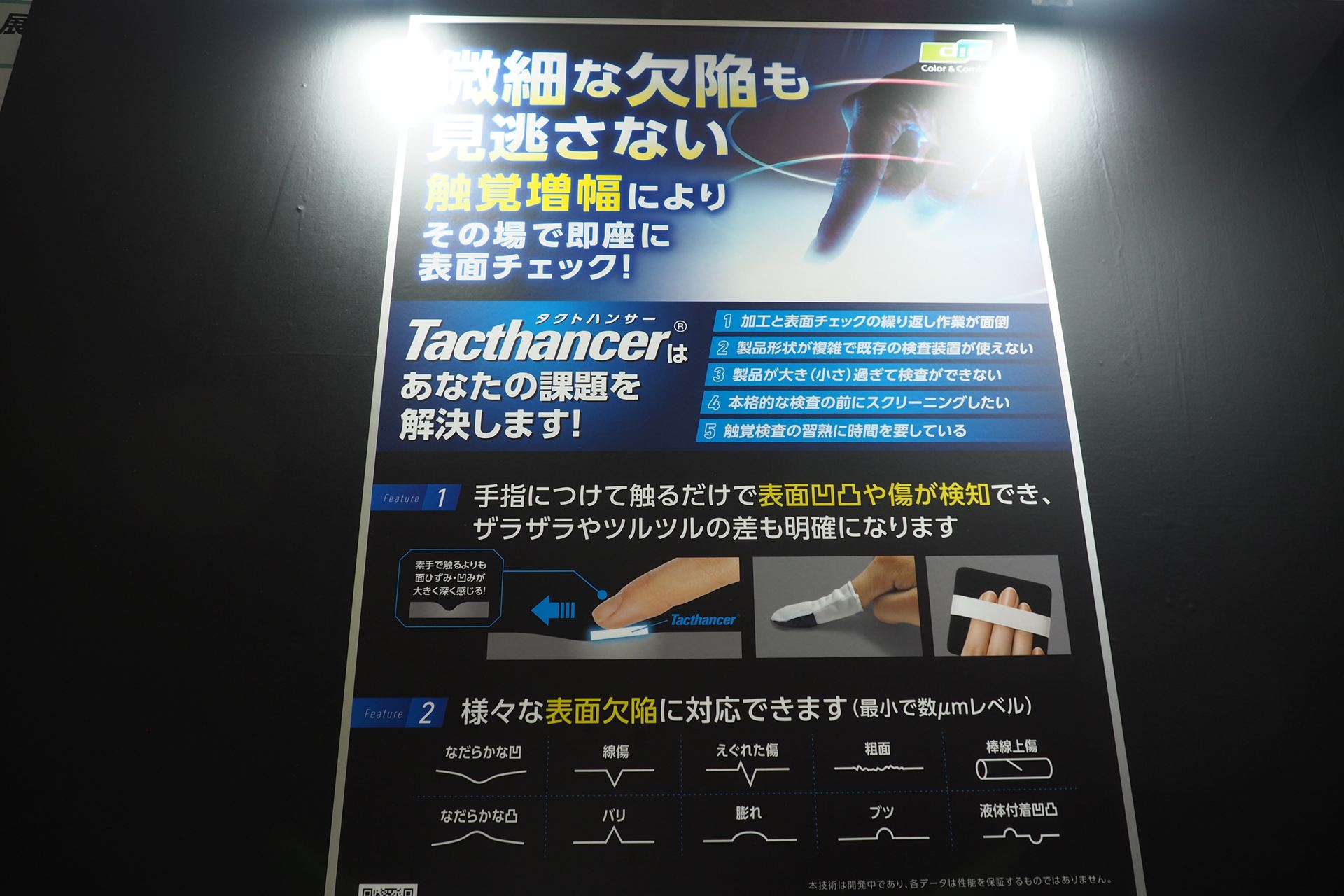DICが開発中のTacthancerについての説明。触覚を増幅する新素材であり、手指につけて触るだけで、微細な凹凸や傷を検知できる