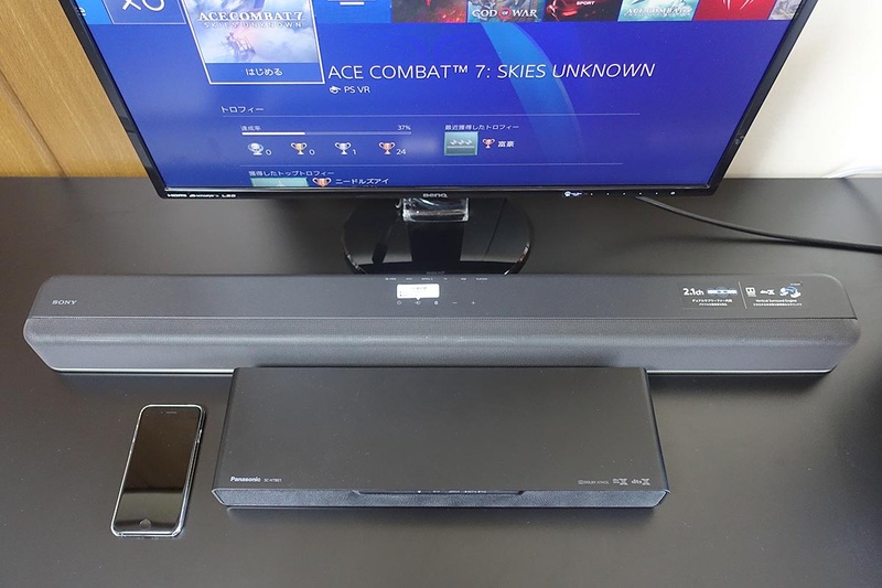 サイズの目安として、筆者所有のiPhone8と並べて撮影。横幅はSC-HTB01の方が小さいが、奥行きはHT-X8500の方が小さい