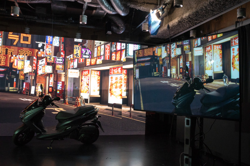 手前のモニターに映っているのが撮影された映像。まるで風景の中にバイクが溶け込んでいるようだ