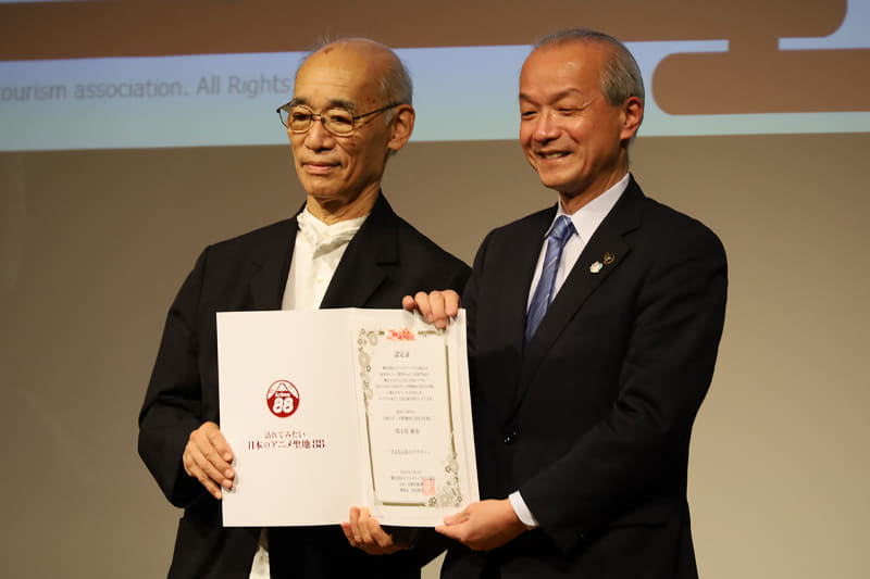 富野氏から認定証を受け取る蕨市の頼髙市長