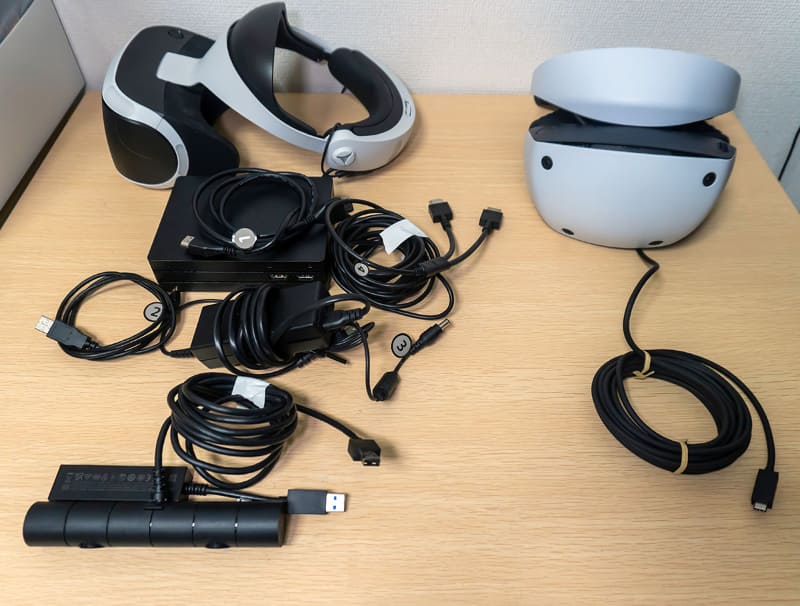 左がPS VR1をPS5で使うために最低限必要なもの。これが右のPS VR2では、ヘッドセット本体だけでいい。ケーブルも本体から伸びているもの1本だけ