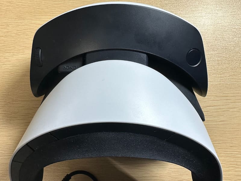 ヘッドセット上部。左がIPD調節用ダイヤルで、右がヘッドセットを前後にスライドさせるボタン。よくみると、「◯×□△」のロゴが……