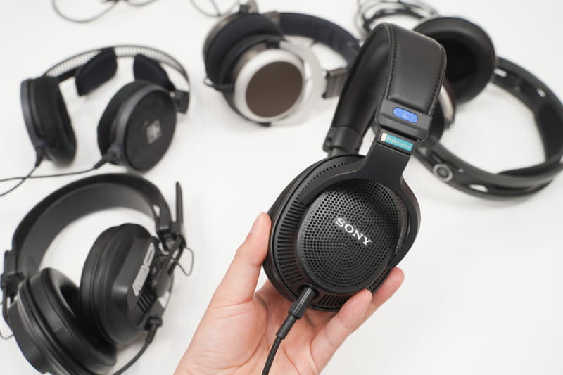 手にしているのがソニーのモニターヘッドフォン「MDR-MV1」