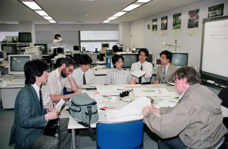 オペレーションルームで、ストーリー会議を行なうメインスタッフ。左から塩沢敏明氏、マックス博士、山藤真二氏、岡野秀樹氏、林伸彦氏、筆者、クロイター氏。写真を撮っているのがラーナー氏なので、ここには写っていない<br><span class="fnt-70">1988年撮影。画像提供：ダグラス・ラーナー氏</span>