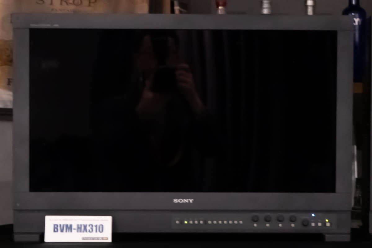 HX310とHX3110の映り込み比較。HX3110の前でも同じようにカメラを構えているが、映り込みはほとんど見えないレベルに抑えられている