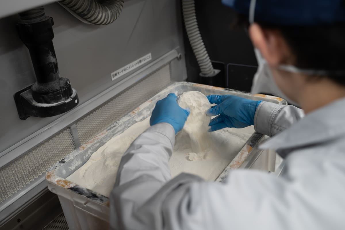 造形したパーツを、発掘作業のようにパウダー状の素材の中から取り出していく