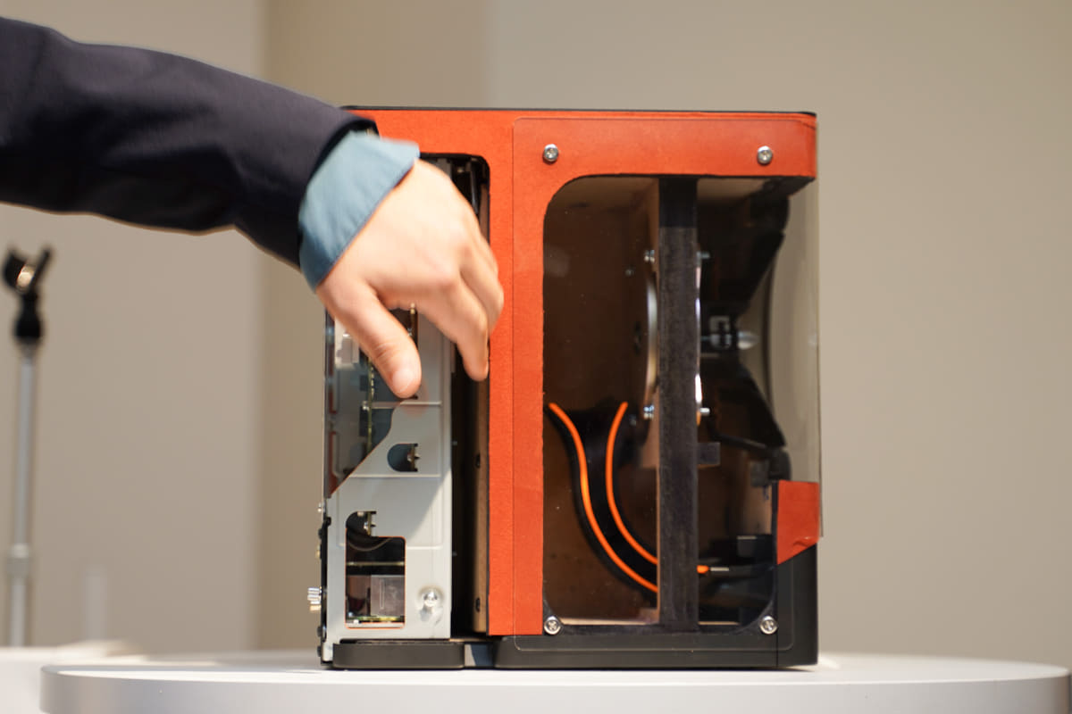 手を入れている部分に空気層がある。右側がスピーカー部分、左側がアンプや電気回路で、両者がセパレートされている