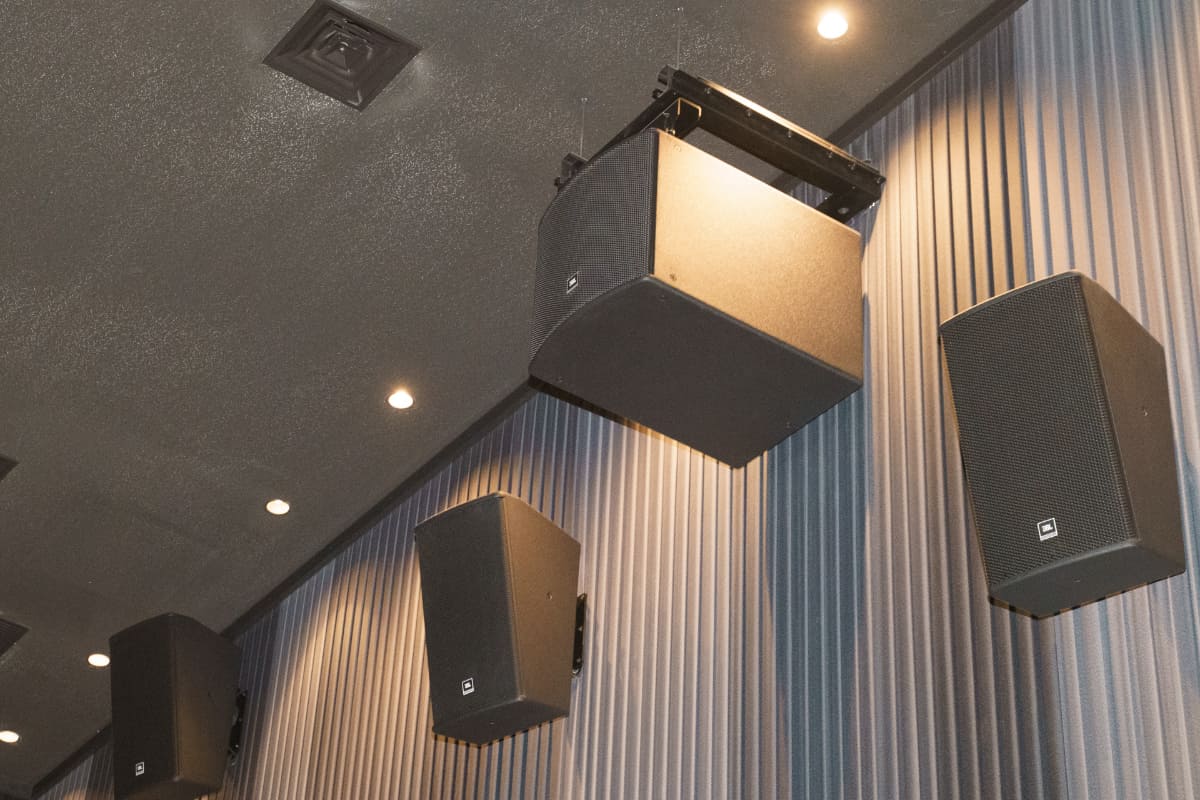 補助用サブウーファーの「JBL ASB6118」が壁面に取り付けられている