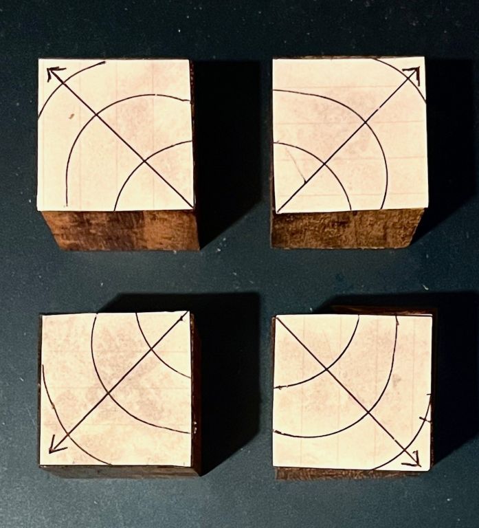機器を指示する脚に紫檀(ローズウッド)の角材を採用。木口(年輪の面)を上下に使うが、分かりやすいように年輪の三重曲線と年輪の軸心からの放射軸が木口の対角線方向と一致する、という想定で模式図を描いた。実際の木材がこのようにきれいな年輪模様を描くことはほとんどないが、説明のためこうした