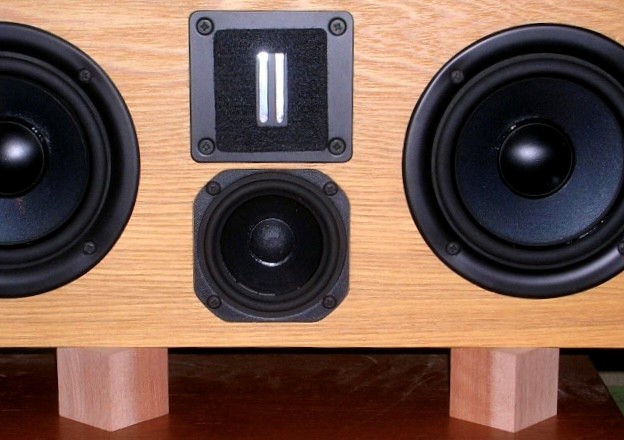 大き目のアサダ桜の角材で設置。垂直の稜線が前にはみ出す置き方に注目。荷重がかかる奥側半分は振動しにくく、手前側は荷重が無いので振動しやすい。結果としてスピーカーの箱の振動を前面開放空間に逃がしやすくなる