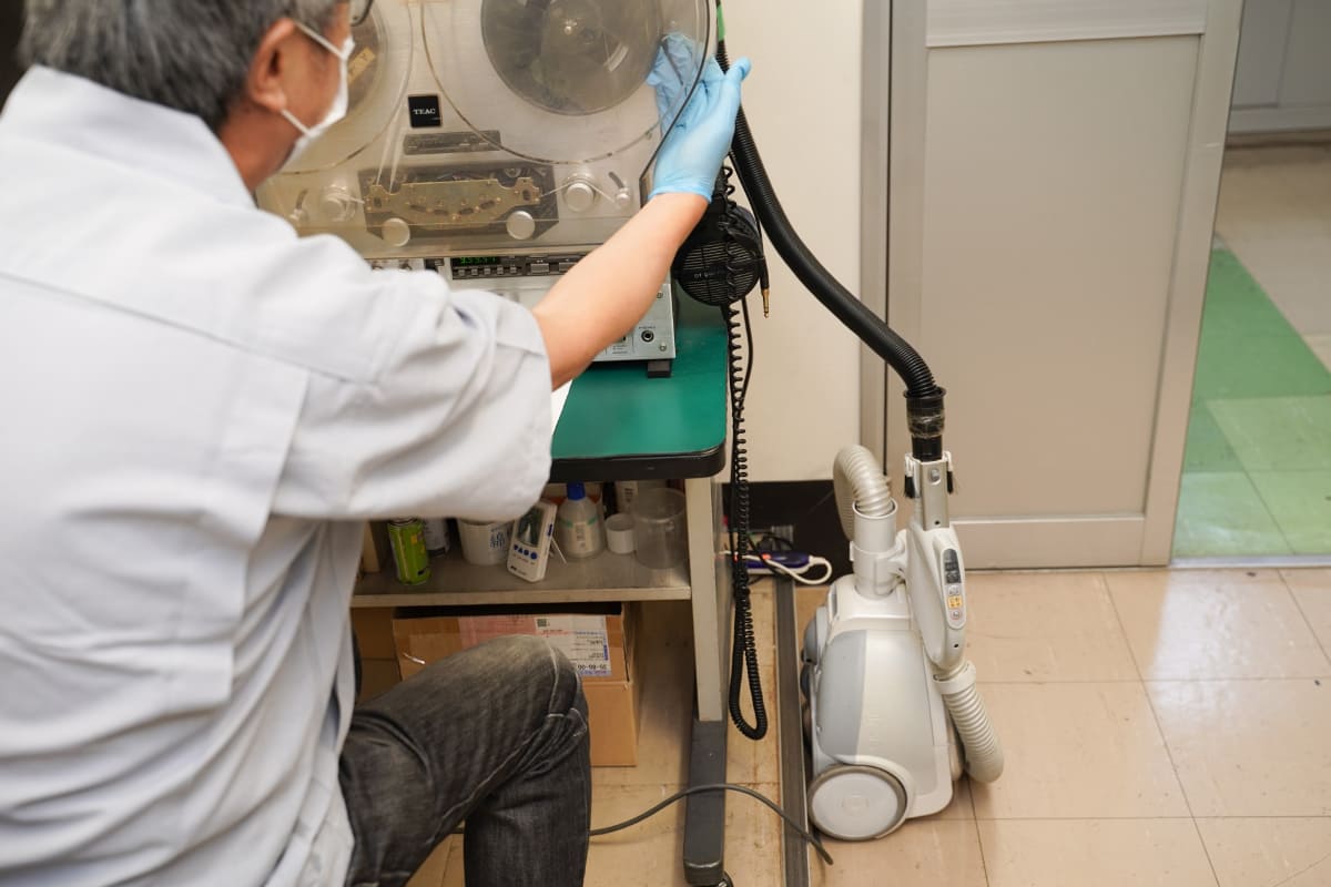 横に設置した掃除機で吸い取りながら、右のリールへと巻き取っていく