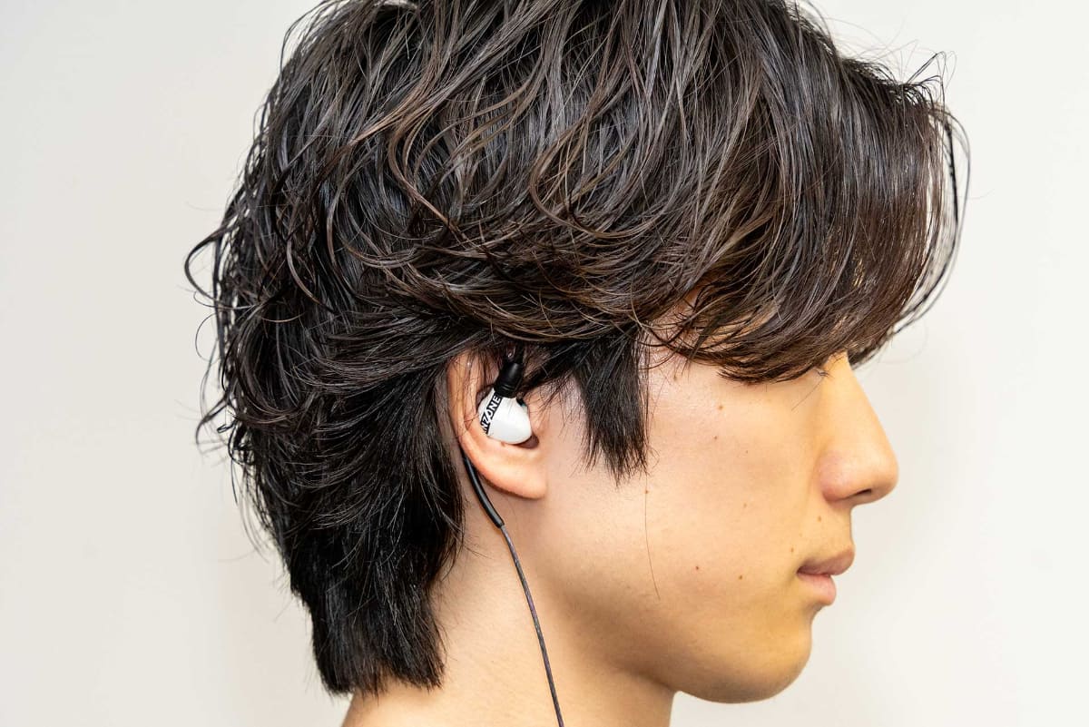 「INZONE E9」を装着したところ。耳からの飛び出しが少ない構造でイヤーマフとも併用しやすいという