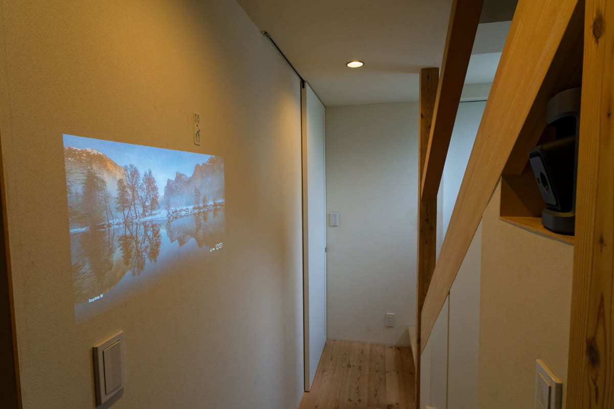 廊下の棚にNebula P1を置いて、向かいの壁に投影