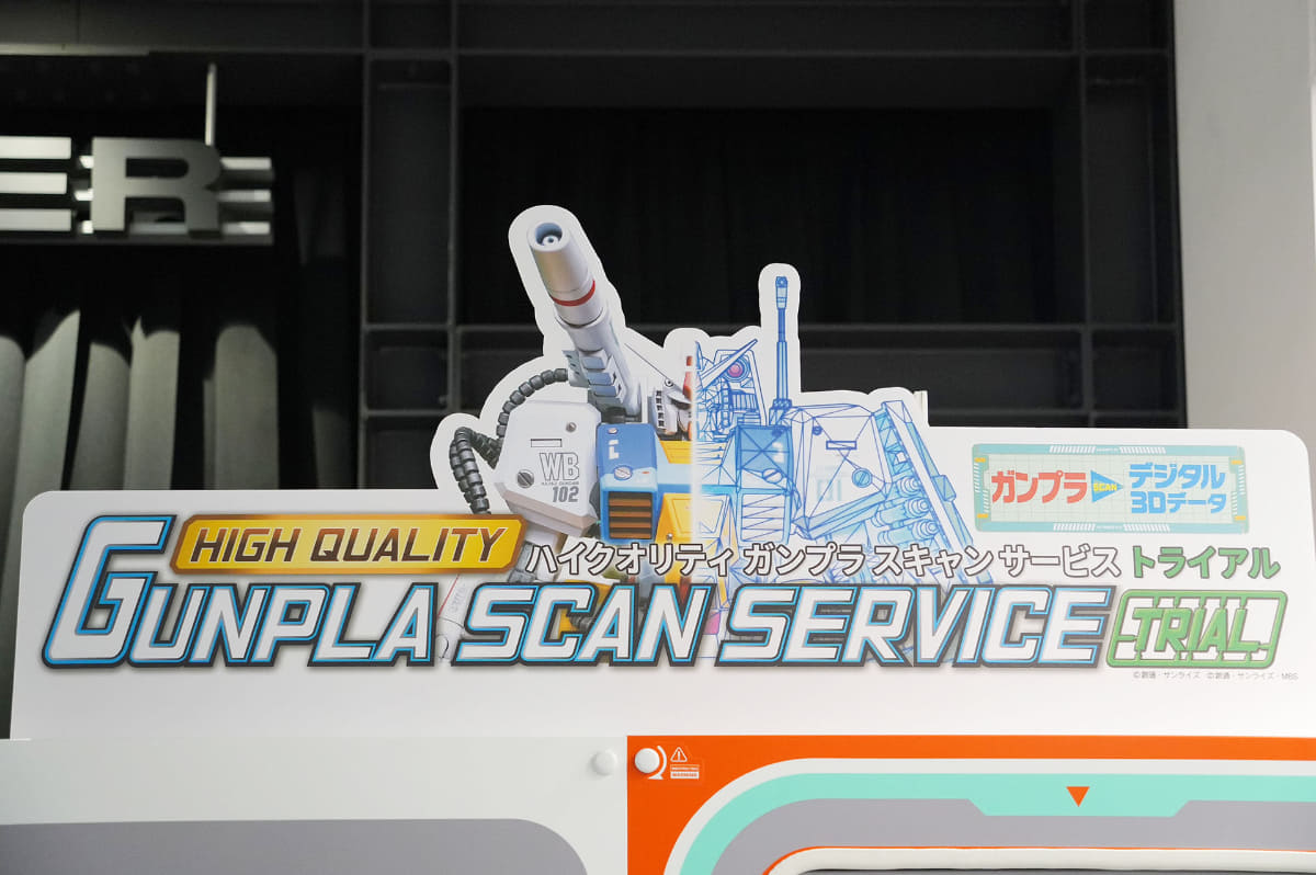 スキャン機の上にある看板。書かれているのが「パーフェクトガンダム」なのはもちろん『プラモ狂四郎』リスペクト