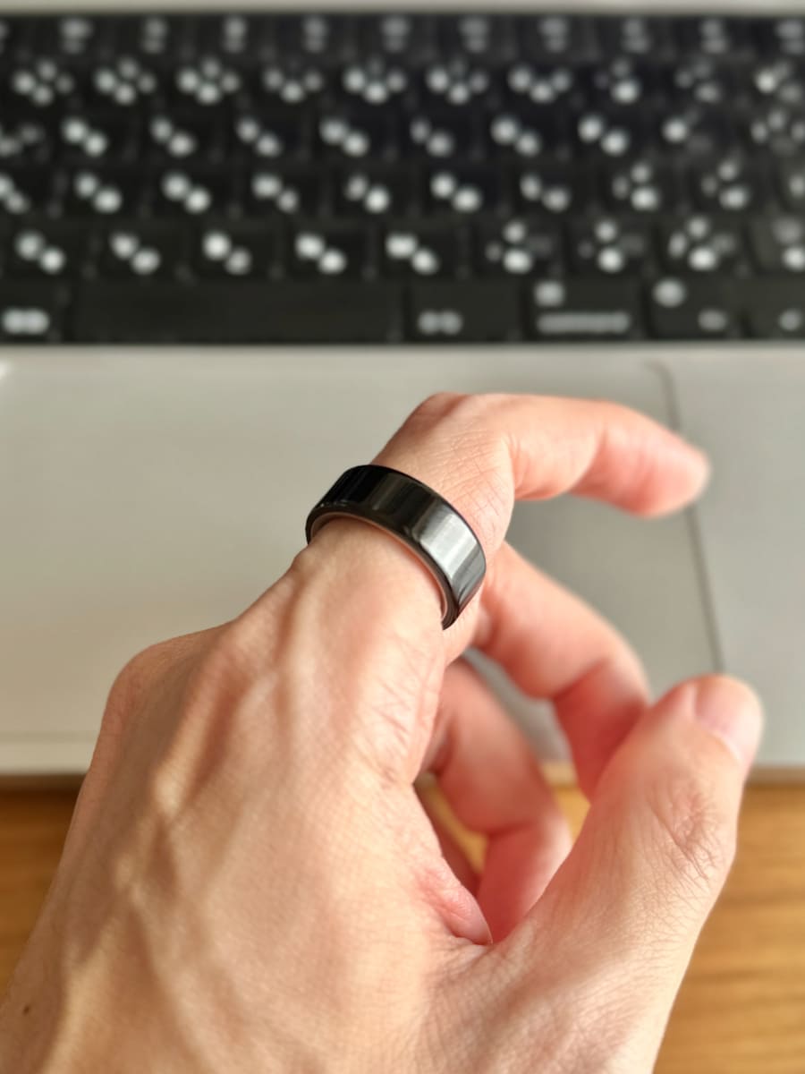 Oura Ring 4(ブラック)。女性並みのサイズ7だった。スマートウォッチに比べれば就寝時の着用ストレスはゼロ。付け外しも簡単なので、ギターを弾くときは右手人差し指にサッと付け替えられたりする。
