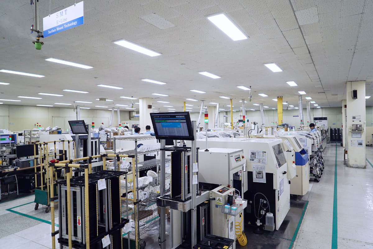 広い工場内には回路基板に表面実装を行なう機械がたくさんある