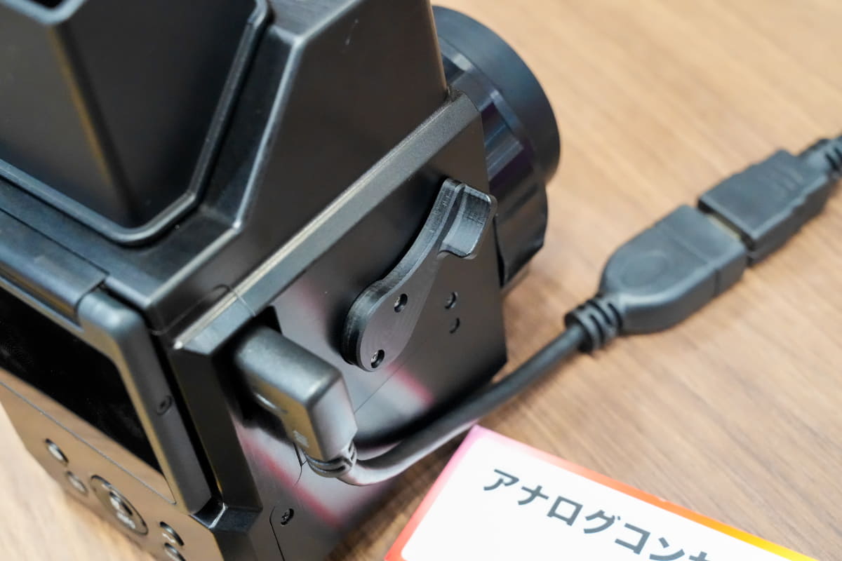 側面のレバーで上のミラーの操作とシャッターを操作する