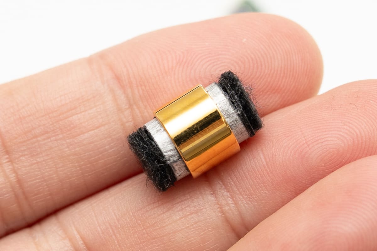 金メッキOFC製リングチャンバーを使って、LCPダイナミックドライバーを2基対向配置している。両サイドに見えている黒いものは、ユニット背後の音を処理する吸音材だ