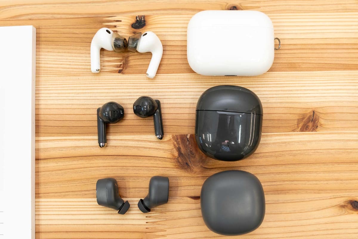 無印良品のワイヤレスイヤフォン2機種(中/下)とアップル「AirPods Pro 3」(上)を並べたところ。無印の2モデルはケースも含めてコンパクト