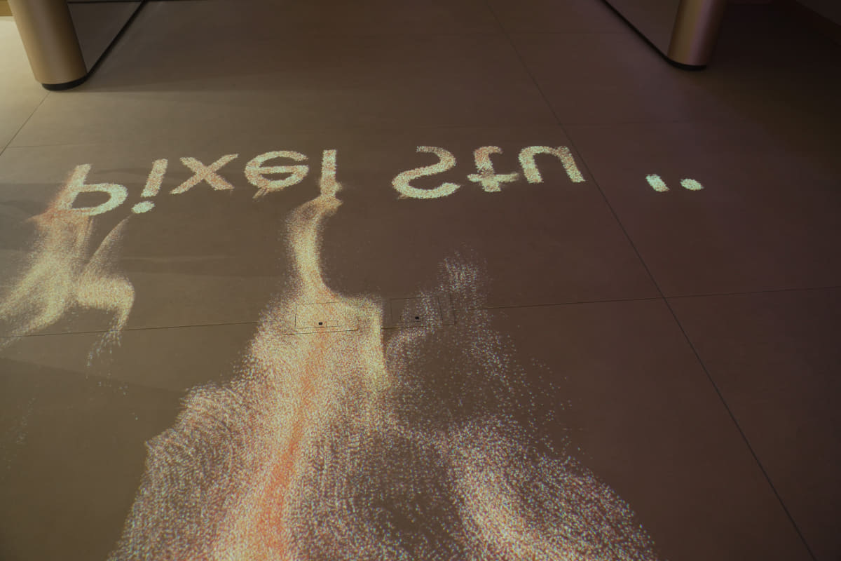 Pixel Studio(2階の名称)に来た記念撮影ポイントも。来場者を知覚し、その足元から砂が流れて、Pixel Studioのロゴが生まれるというエフェクトと共に、自撮りができる