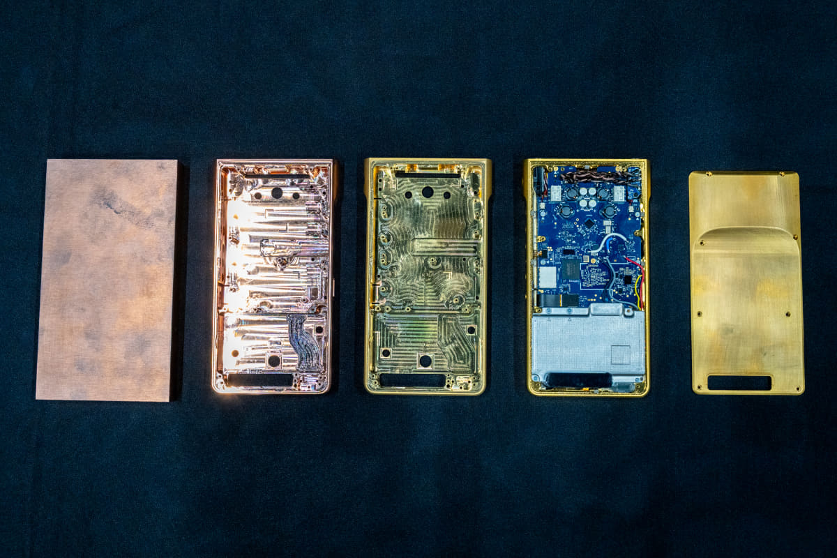 NW-WM1ZM3のシャーシ。左から削り出し前の銅、削り出されたシャーシ、金メッキを施したもの、基板を入れた状態、OFC削り出しのリアシャーシ