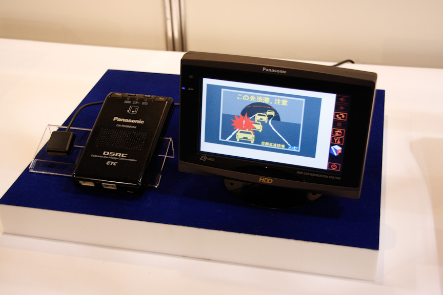 パナソニックはITS-Safety2010で自動車メーカー各社が搭載するITS共通車載器（写真左）と国土交通省がモニターで使用するDSRC車載器（写真右）を展示。ITS共通車載器はDSRCによるスマートウェイの情報のほか、ナビ本体の光ビーコンを使ってDSSSプロジェクトの情報も受信可能